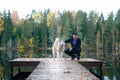 Man with a husky dog Ã¢â¬â¹Ã¢â¬â¹on the pier of a beautiful lake, autumn mood. Young man training a dog in nature